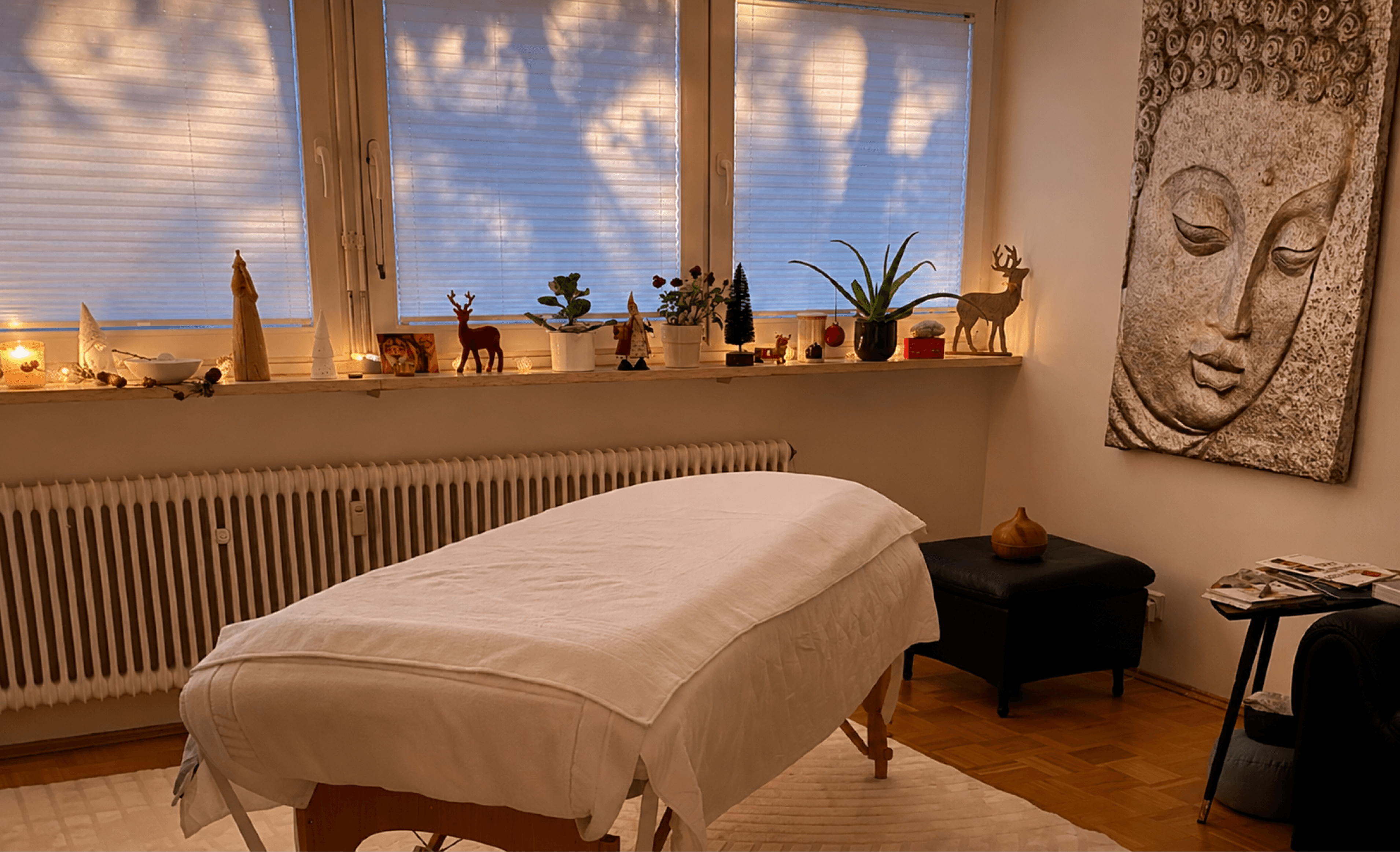 Behandlungsraum mit Massageliege und warmer Abendstimmung.